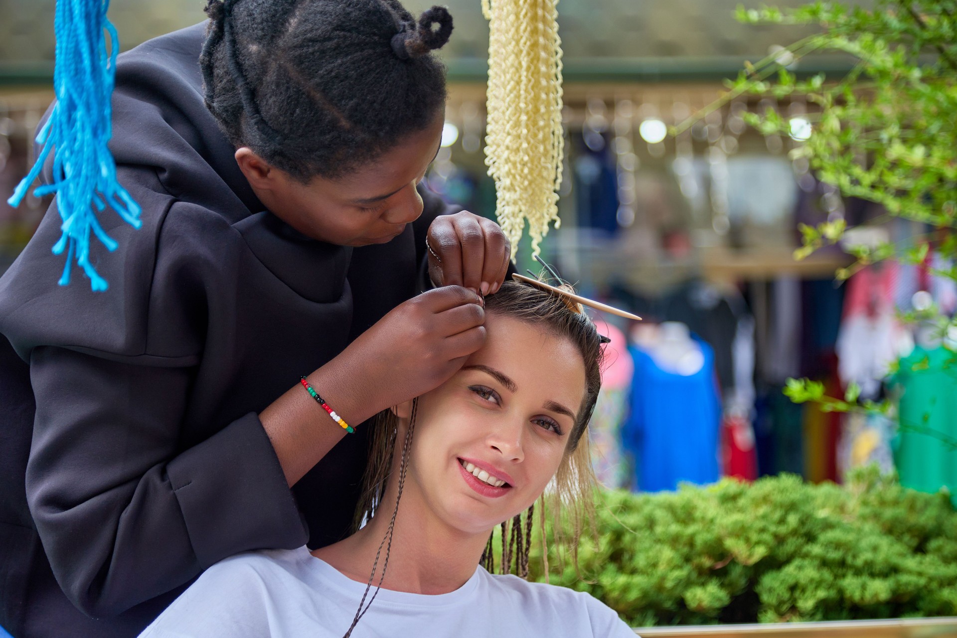 Process of weaving long African braids by a dark-skinned girl hairdresser
